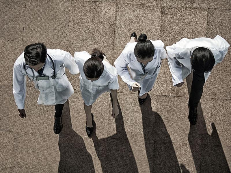 Four health care workers walking in a row