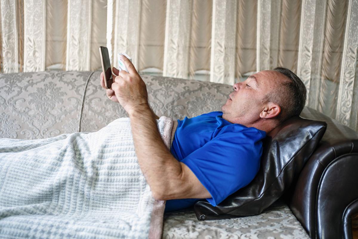 Man on couch using a smart device