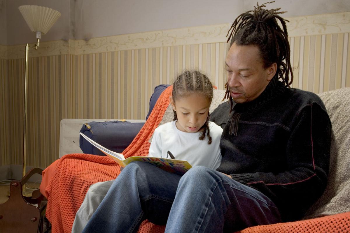 Father helping his daughter with her homework. 